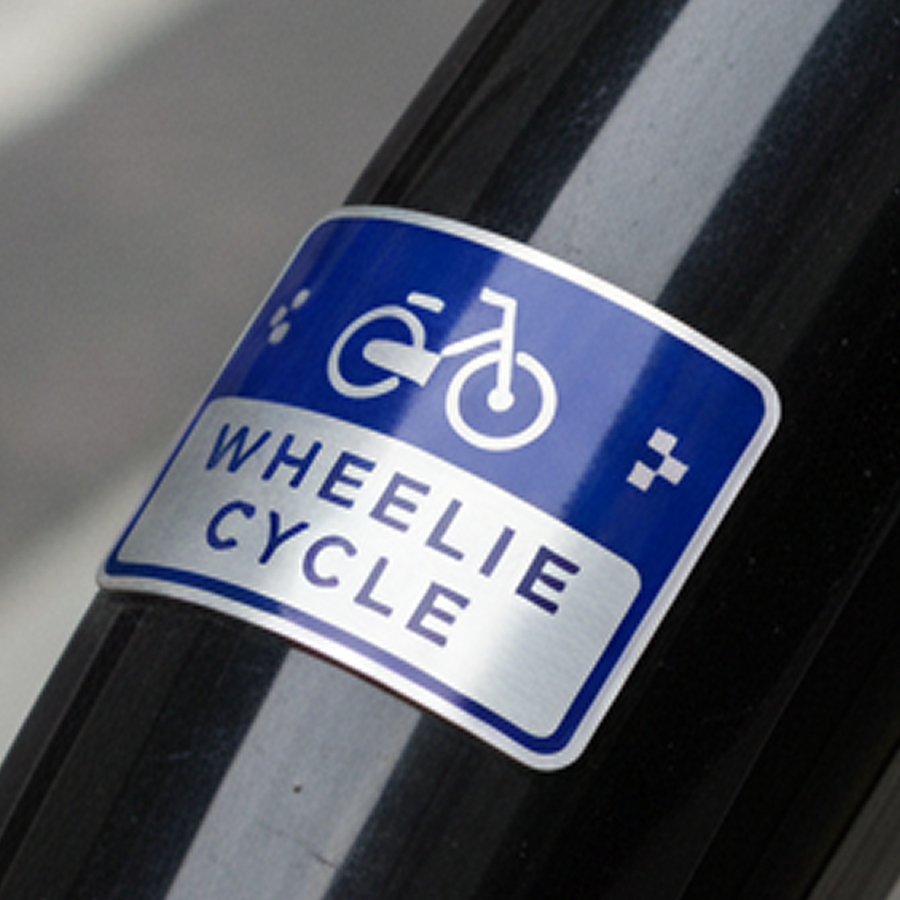 Cartello 'Wheelie Cycle' blu e bianco su una superficie nera
