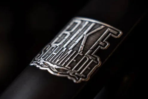 Bike Schmiede cut-out metal label on a dark frame