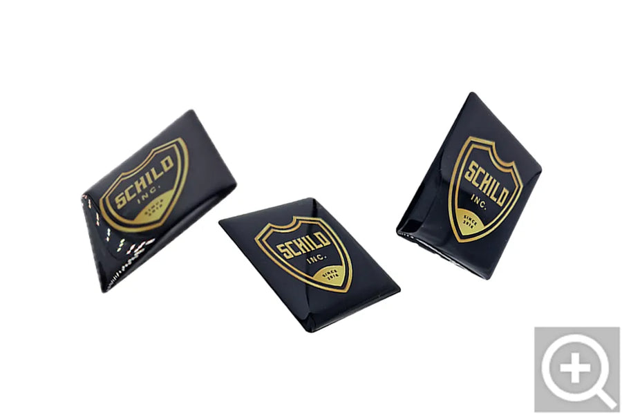 Tre etichette doming Schild Inc con logo dorato
